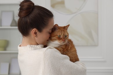 Woman with cute cat in light room at home