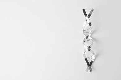 DNA molecular chain model made of metal on white background, top view. Space for text