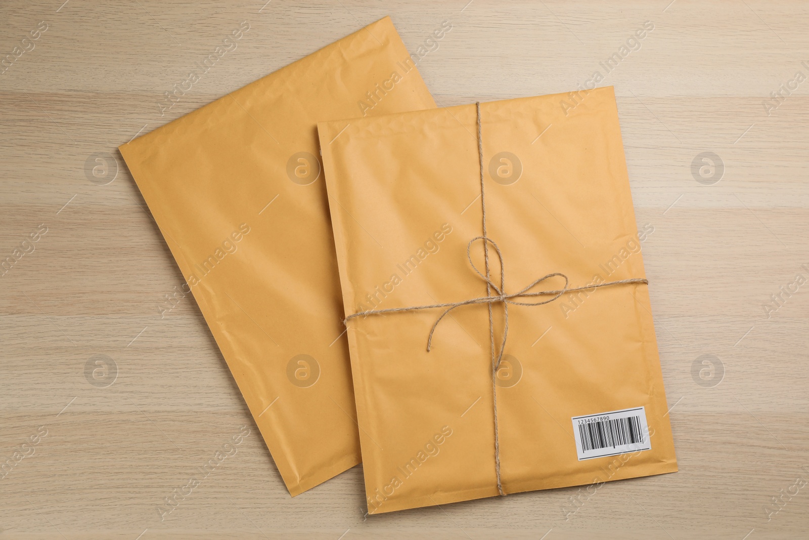 Photo of Padded envelopes on wooden background, flat lay