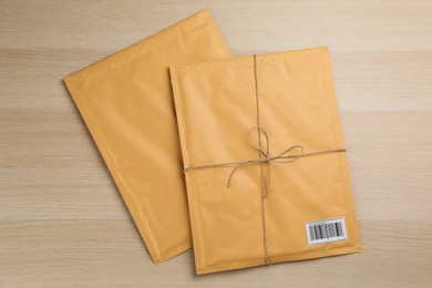 Photo of Padded envelopes on wooden background, flat lay