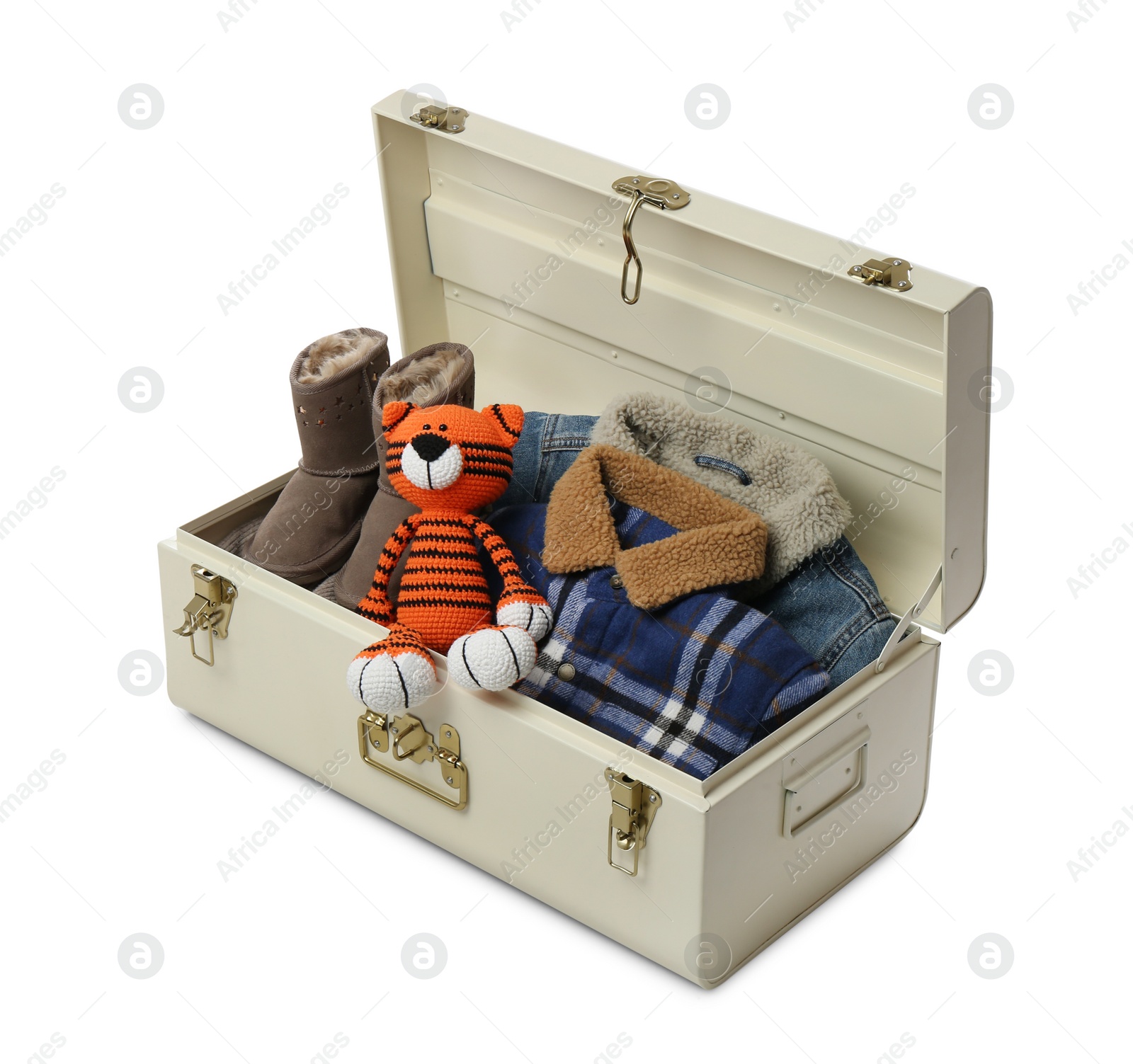 Photo of Stylish storage trunks with warm clothes, shoes and tiger toy on white background. Interior elements