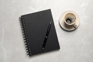 Notebook, pen and coffee on light grey marble table, flat lay