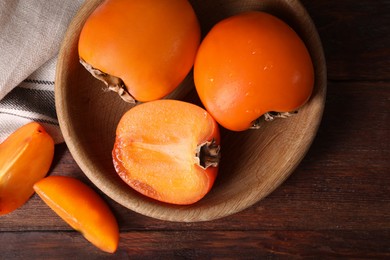 Photo of Delicious ripe persimmons on wooden table, top view