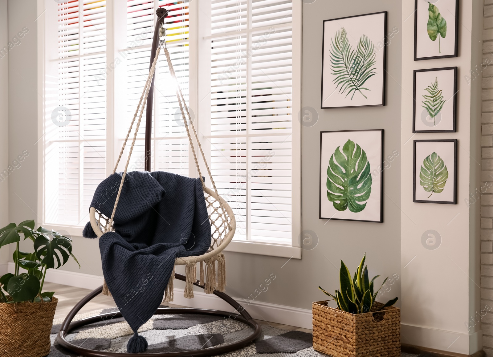 Photo of Stylish room interior with artworks and hanging chair