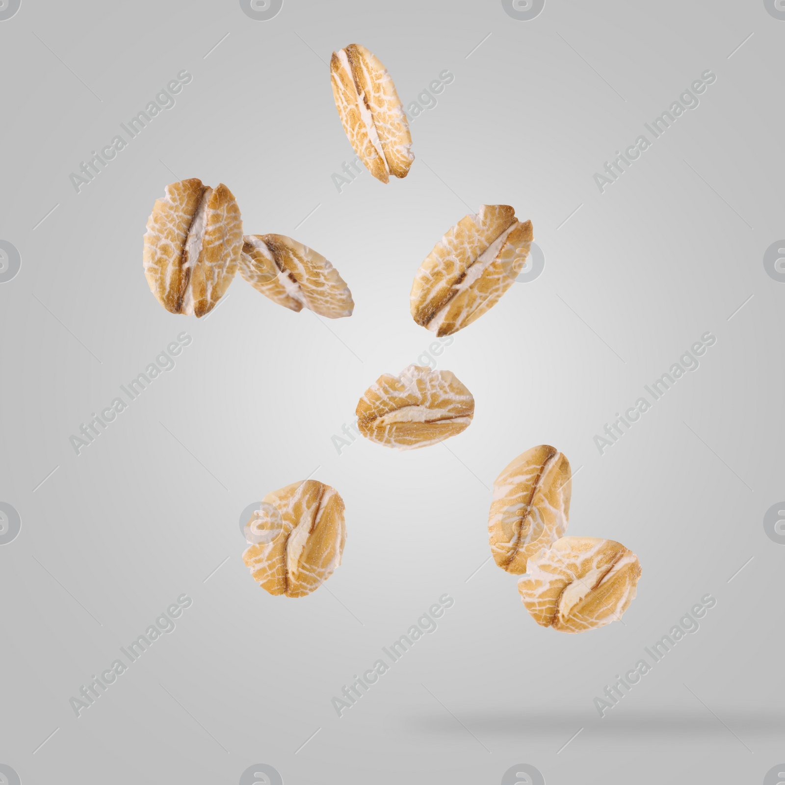 Image of Rolled oat flakes falling on grey background