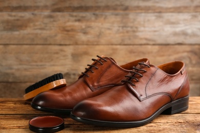 Photo of Shoe care products and footwear on wooden table