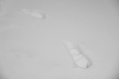 Photo of Footprints on white snow outdoors. Winter weather