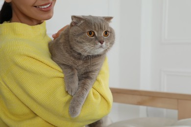 Photo of Woman with her adorable cat at home, closeup