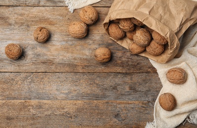 Photo of Flat lay composition with walnuts and space for text on wooden background