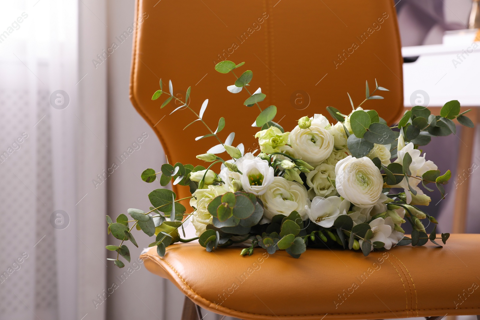 Photo of Beautiful bouquet on leather chair indoors, closeup. Interior element