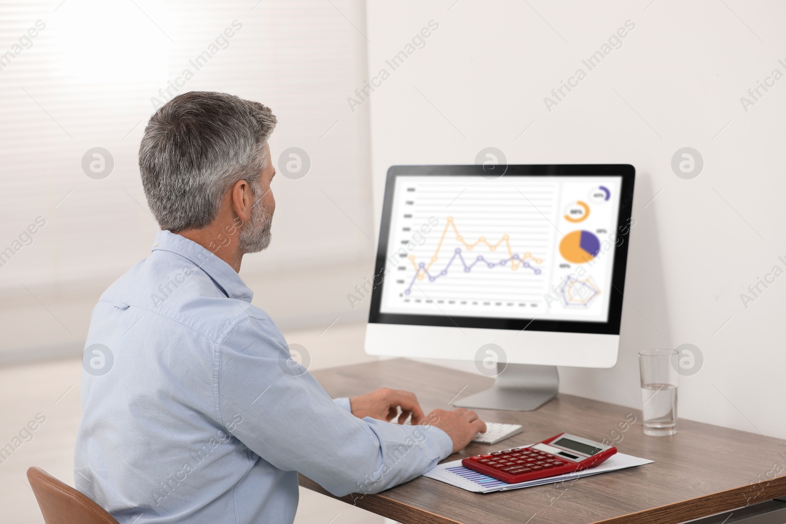 Photo of Professional accountant working at wooden desk in office