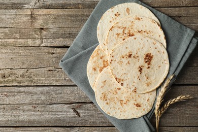 Tasty homemade tortillas and spikes on wooden table, top view. Space for text