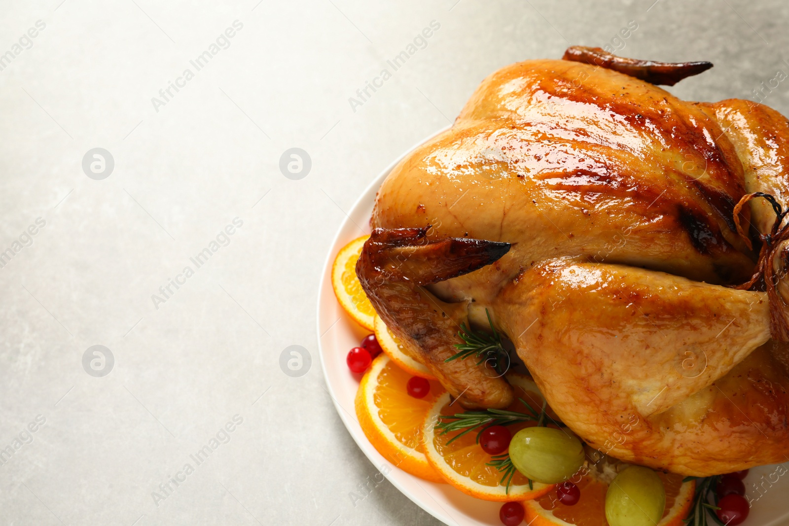 Photo of Platter of cooked turkey with garnish on grey background. Space for text