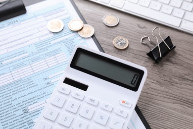 Photo of Tax accounting. Calculator, document, coins, keyboard and binder clip on wooden table, closeup