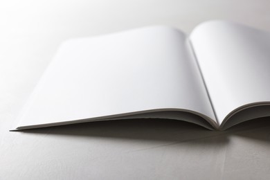 Open notebook with blank pages on grey textured table, closeup. Mockup for design