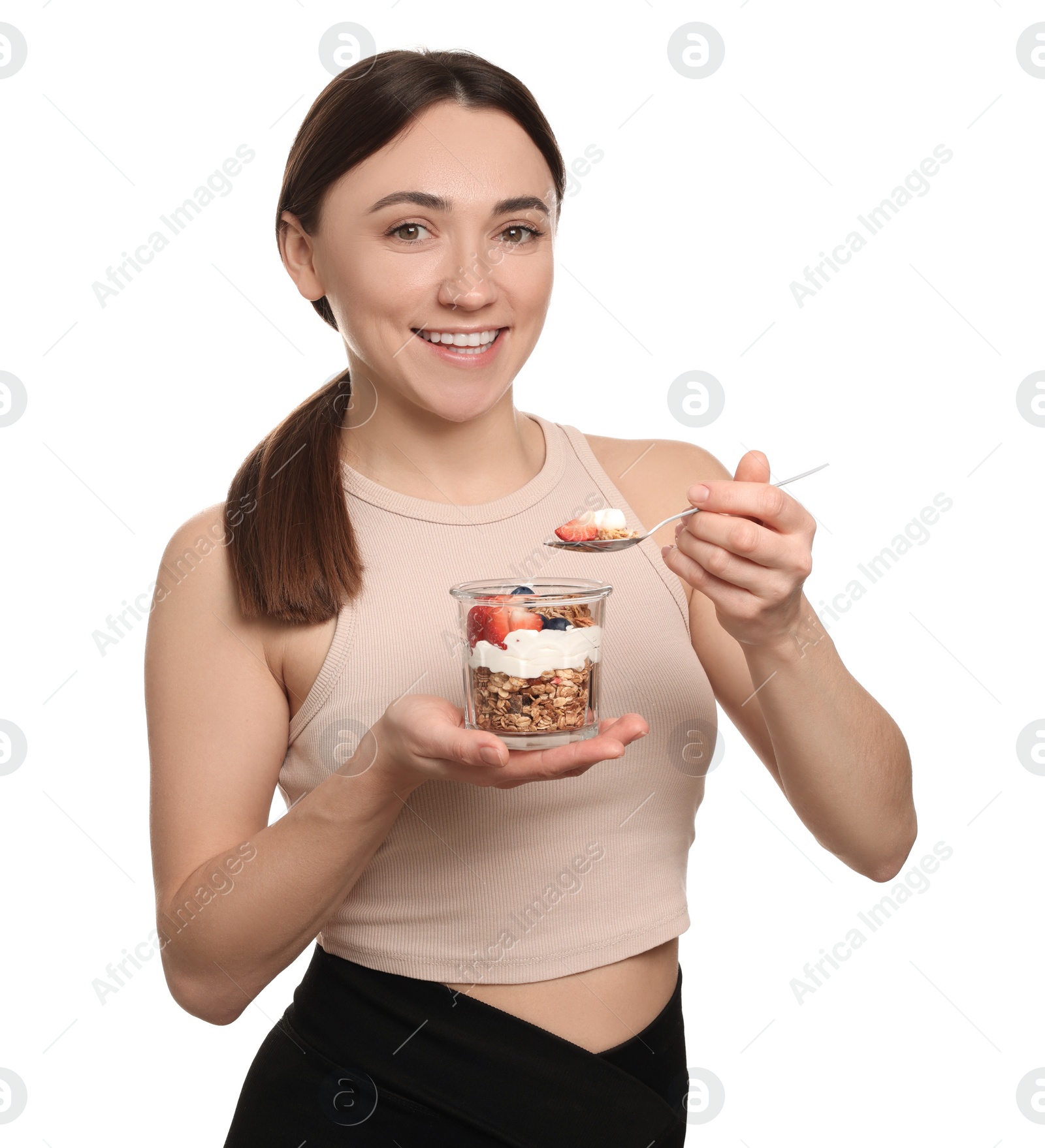 Photo of Happy woman eating tasty granola with fresh berries and yogurt on white background