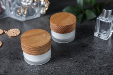 Photo of Jars with cream on black table. Cosmetic product