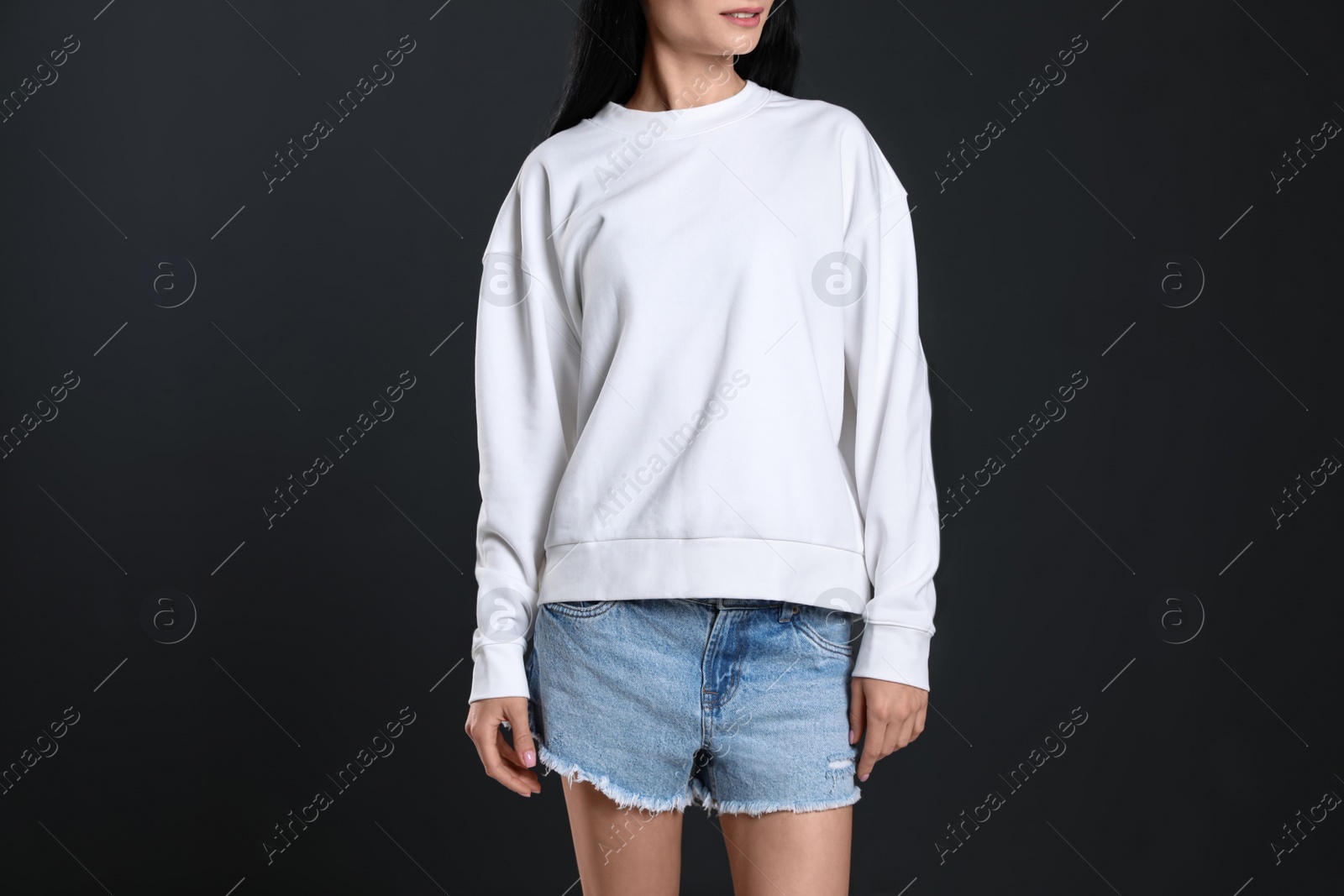 Photo of Young woman in sweater on black background, closeup. Mock up for design