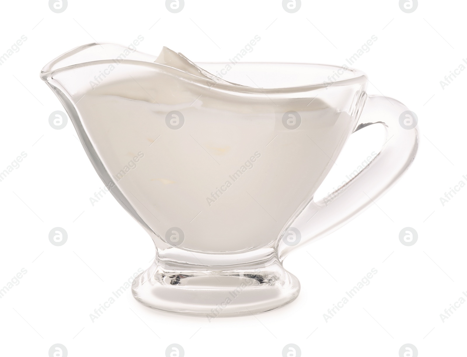 Photo of Glass sauce boat with sour cream isolated on white