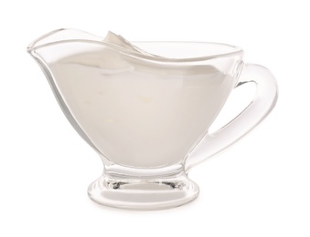 Glass sauce boat with sour cream isolated on white