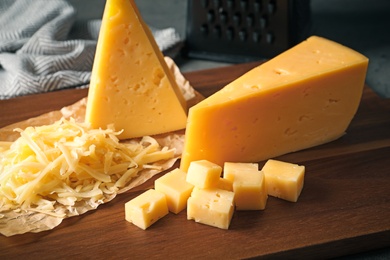 Grated and cut delicious cheese on board