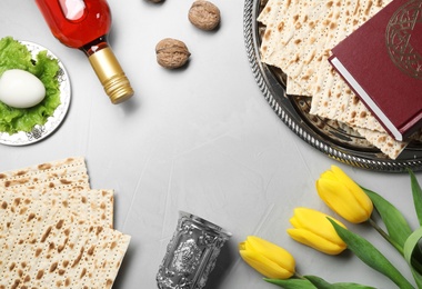 Photo of Flat lay composition with symbolic Passover (Pesach) items on light background, space for text