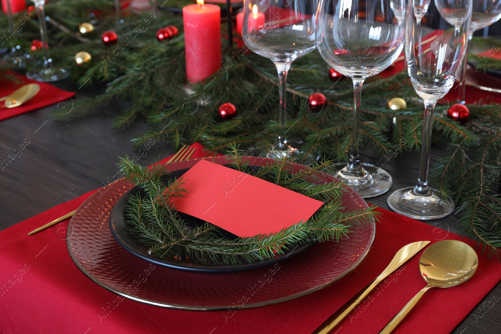 Photo of Elegant Christmas place setting with blank card and festive decor on table, closeup