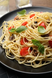 Delicious pasta with anchovies, tomatoes and basil on plate