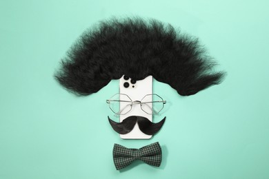 Photo of Flat lay composition with artificial moustache and glasses on turquoise background