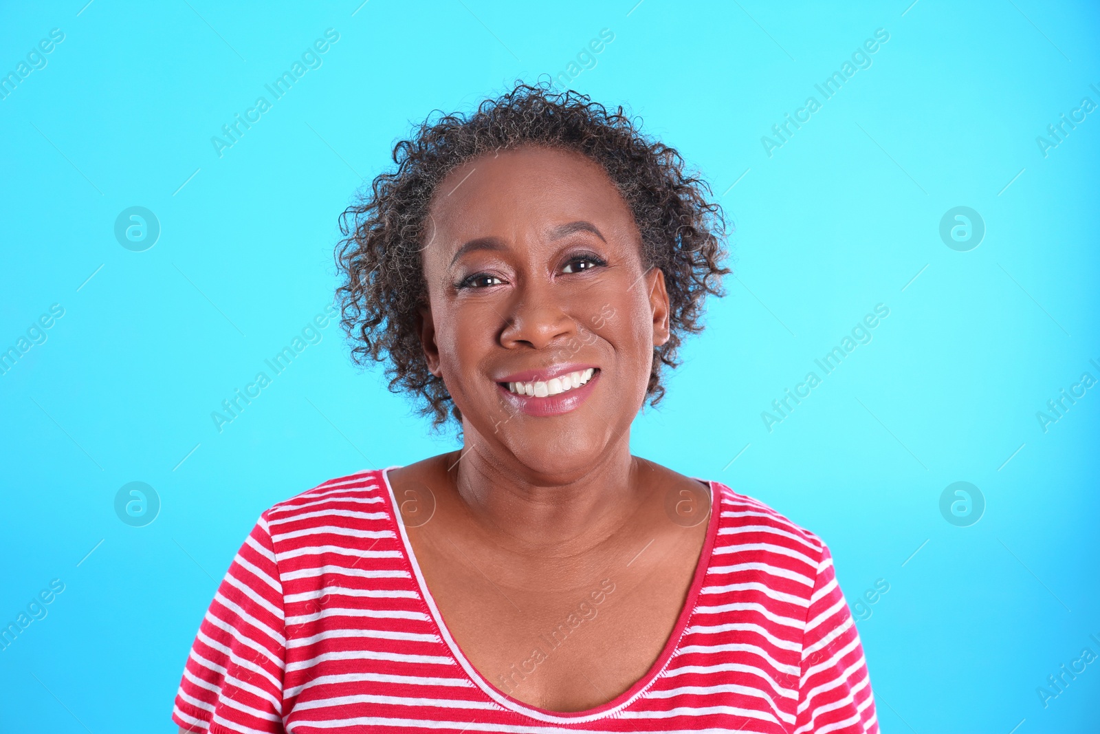 Photo of Portrait of happy African-American woman on light blue background