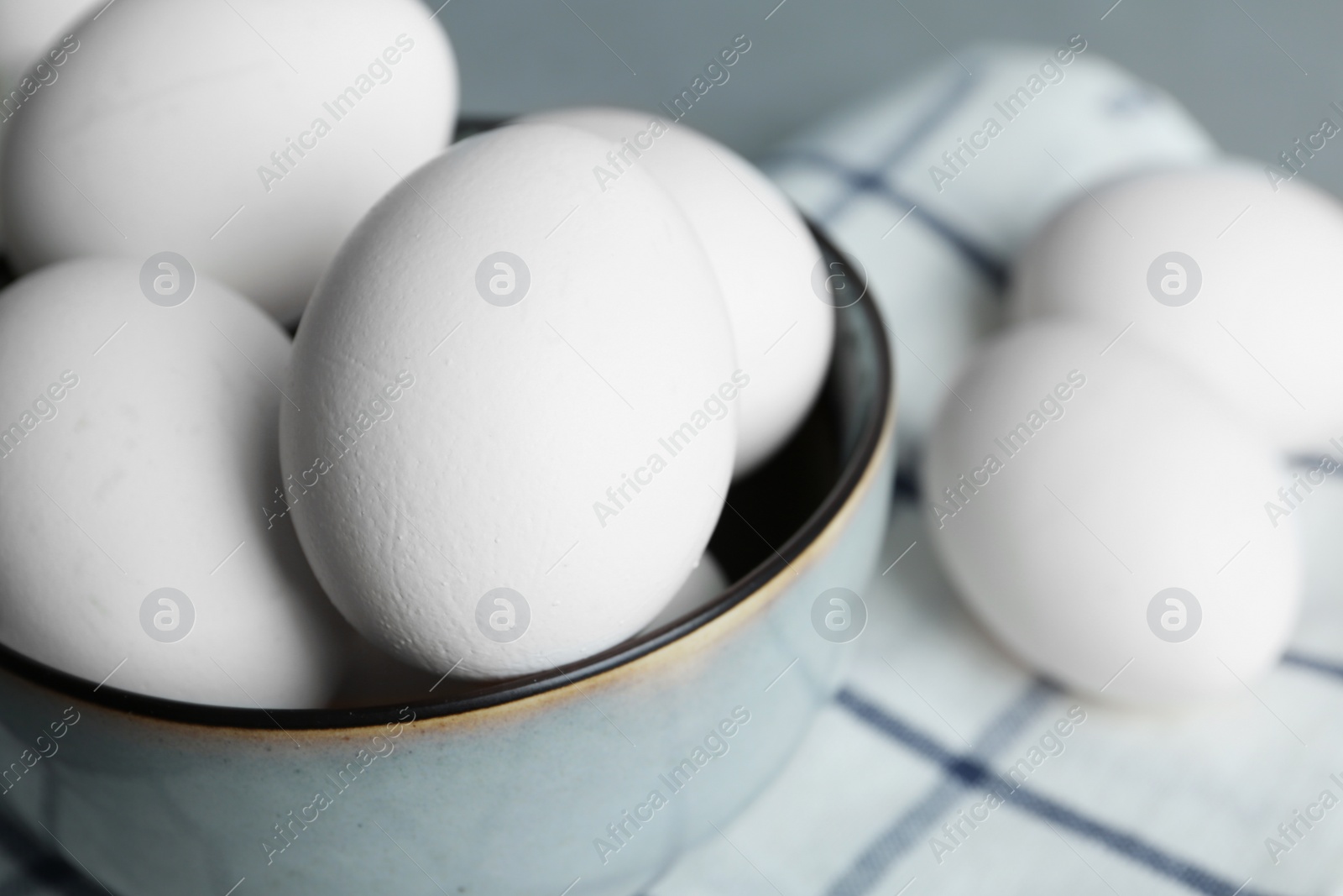 Photo of Chicken eggs in bowl on table, closeup