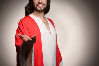 Photo of Jesus Christ reaching out his hand on beige background, closeup. Space for text