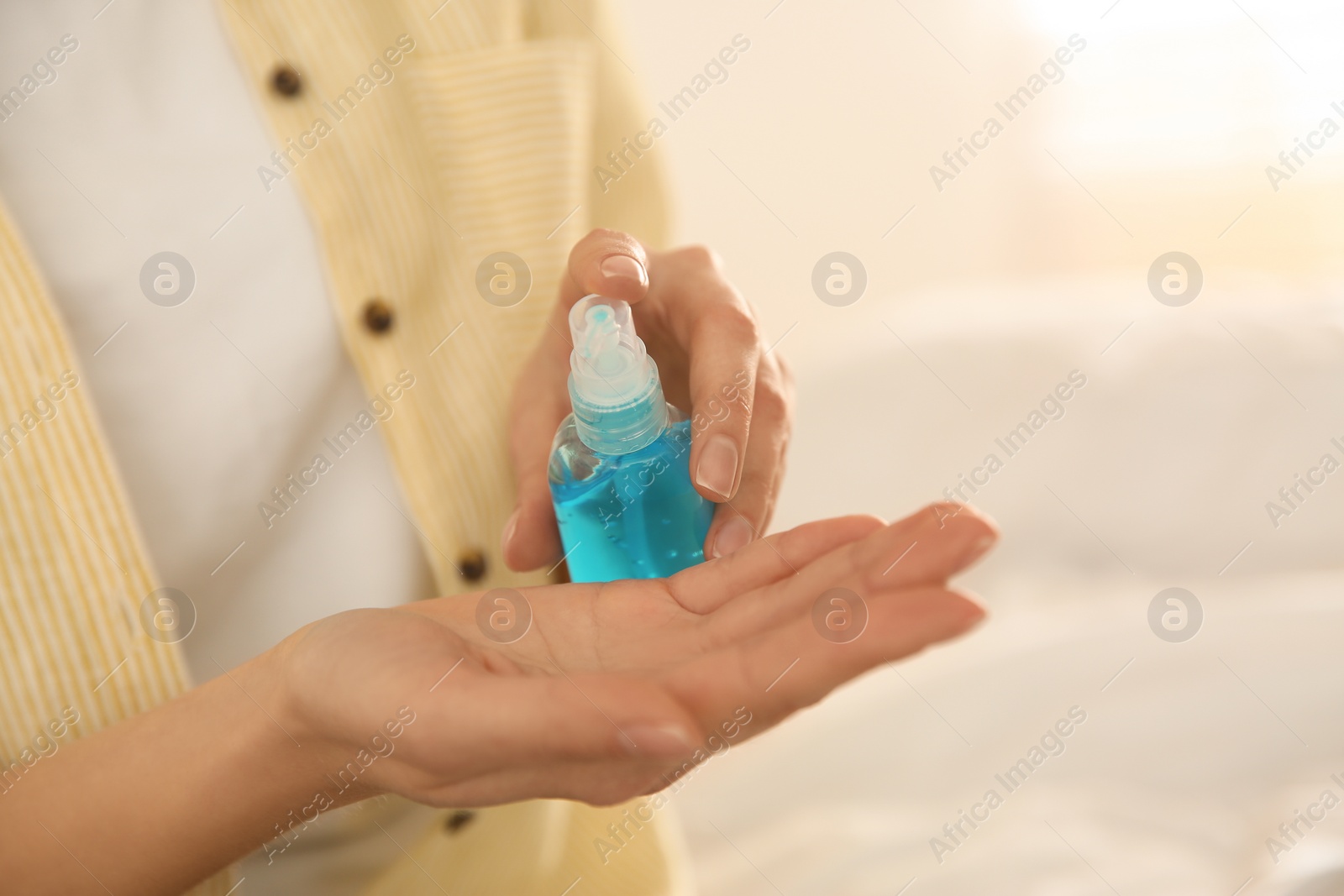 Photo of Woman applying antiseptic gel on blurred background, closeup