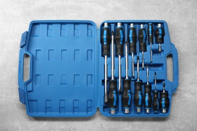 Photo of Set of screwdrivers in open toolbox on grey textured table, top view