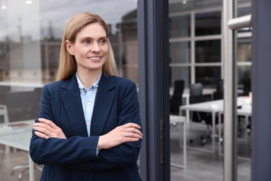 Happy real estate agent in suit near office outdoors. Space for text