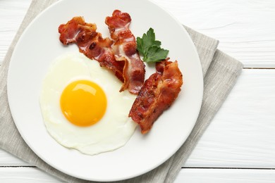 Delicious breakfast with sunny side up egg on white wooden table, top view