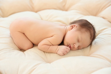 Adorable newborn baby sleeping on bed
