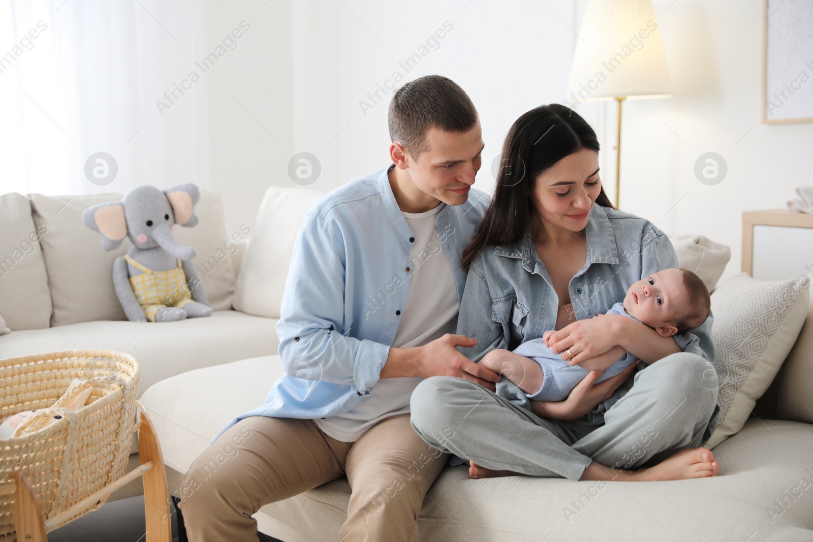 Photo of Happy family with cute baby on sofa at home