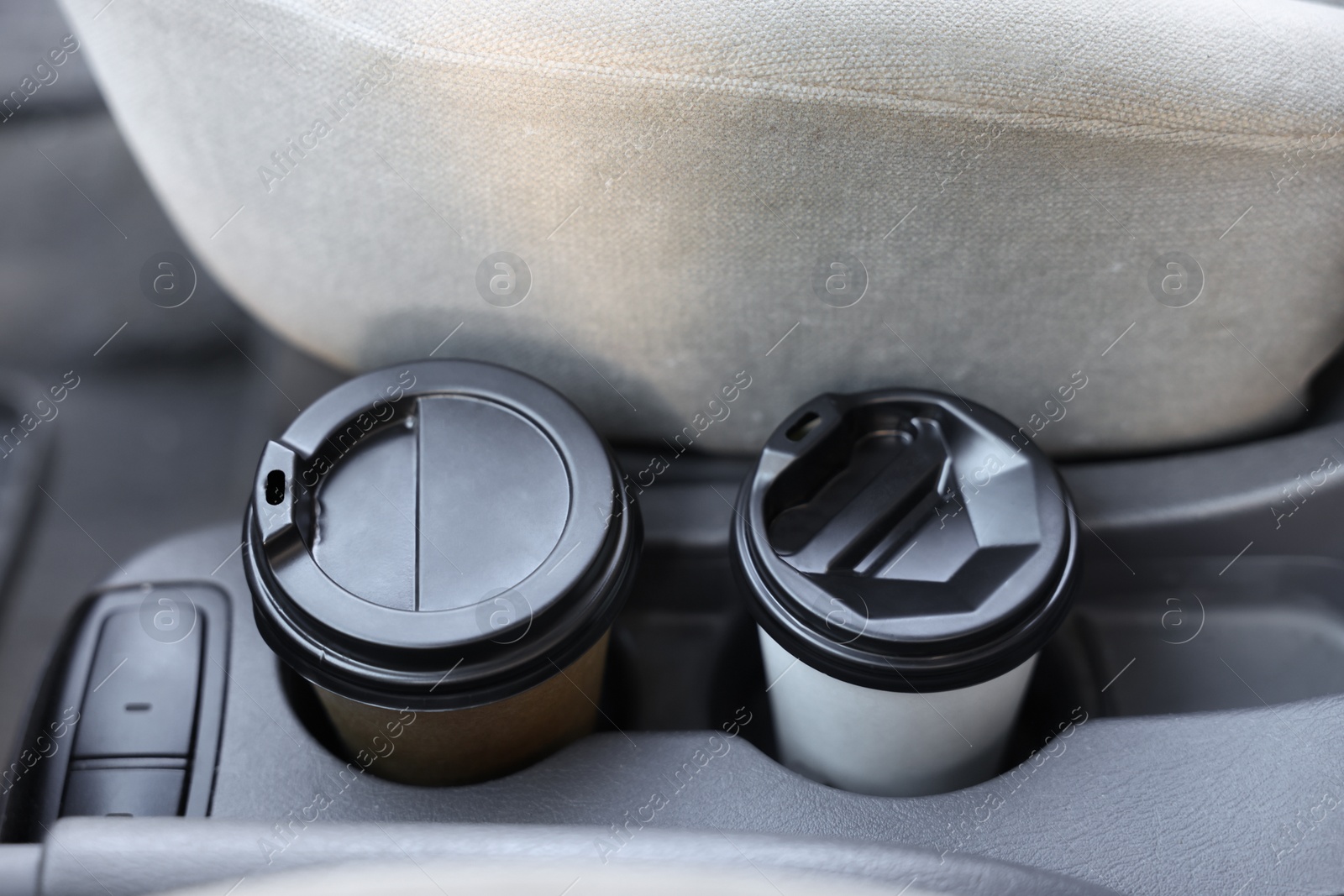 Photo of Coffee to go. Paper cups with tasty drink in holder inside of car, closeup