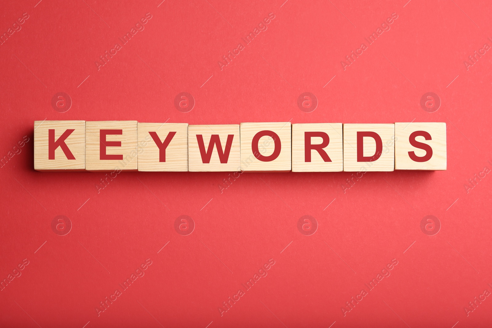 Photo of Wooden cubes with word KEYWORDS on red background, flat lay