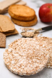 Photo of Rice cakes and rusks on white marble table, closeup
