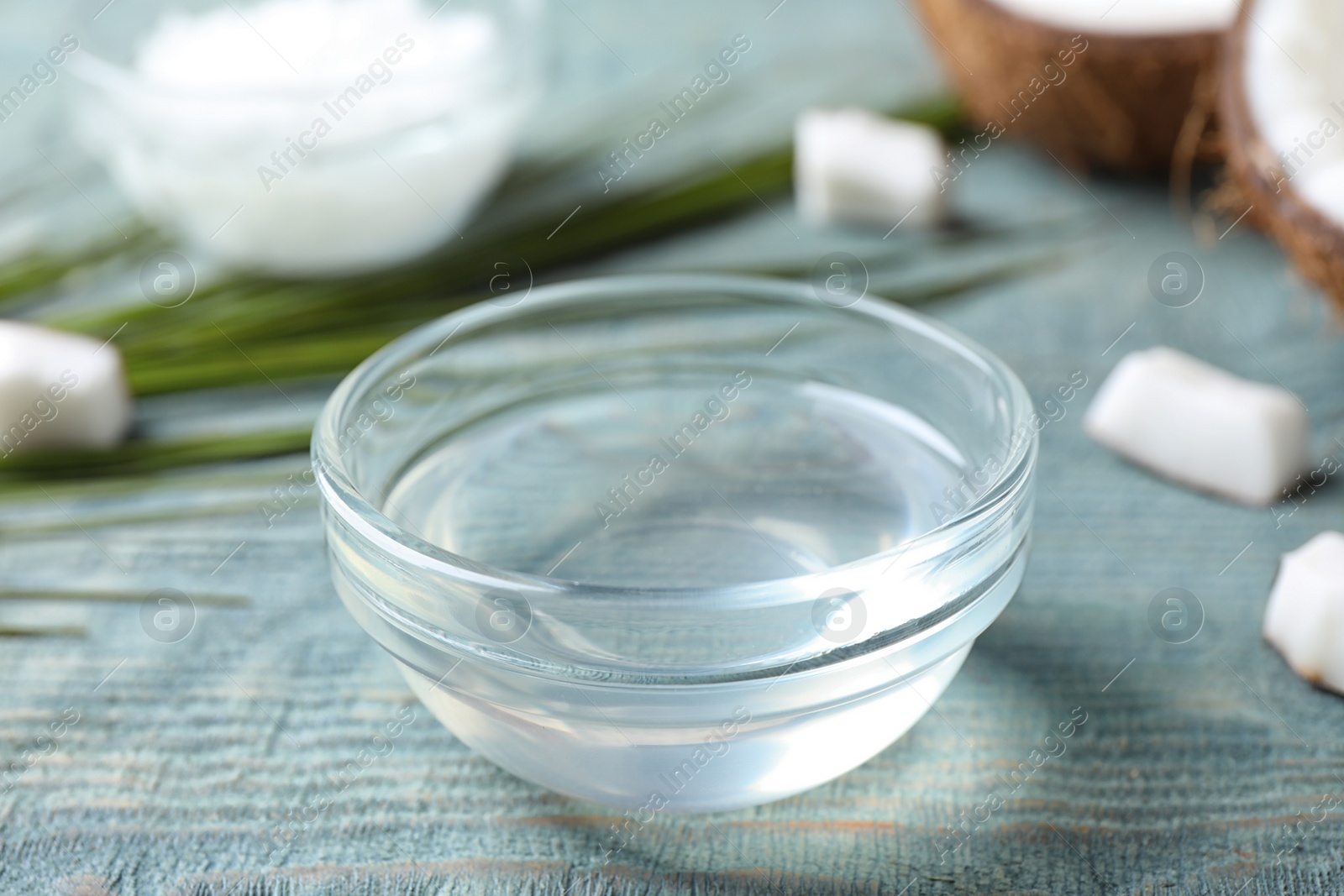 Photo of Coconut oil on light blue wooden table, closeup