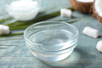 Photo of Coconut oil on light blue wooden table, closeup