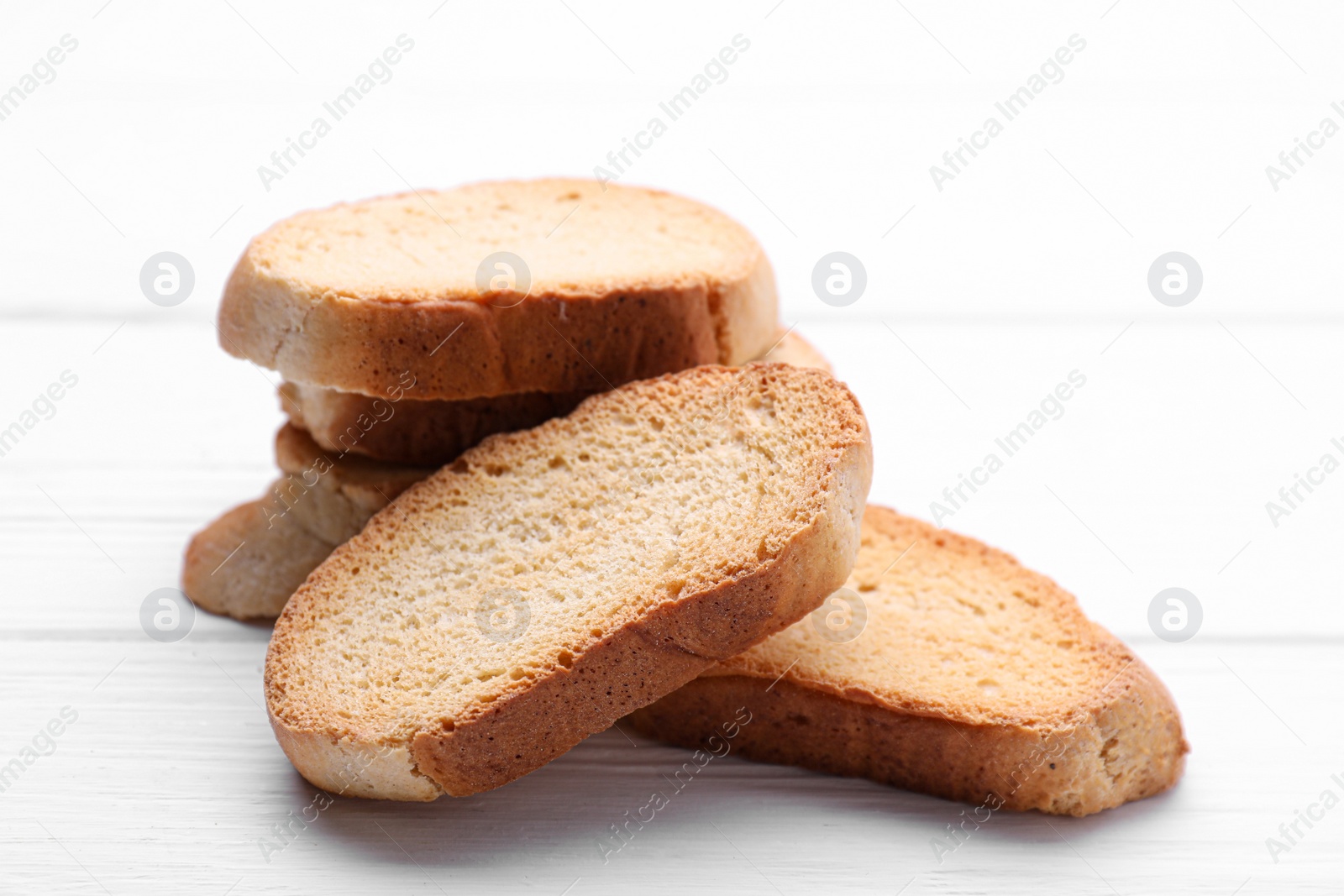 Photo of Tasty hard chuck crackers on white wooden table, closeup