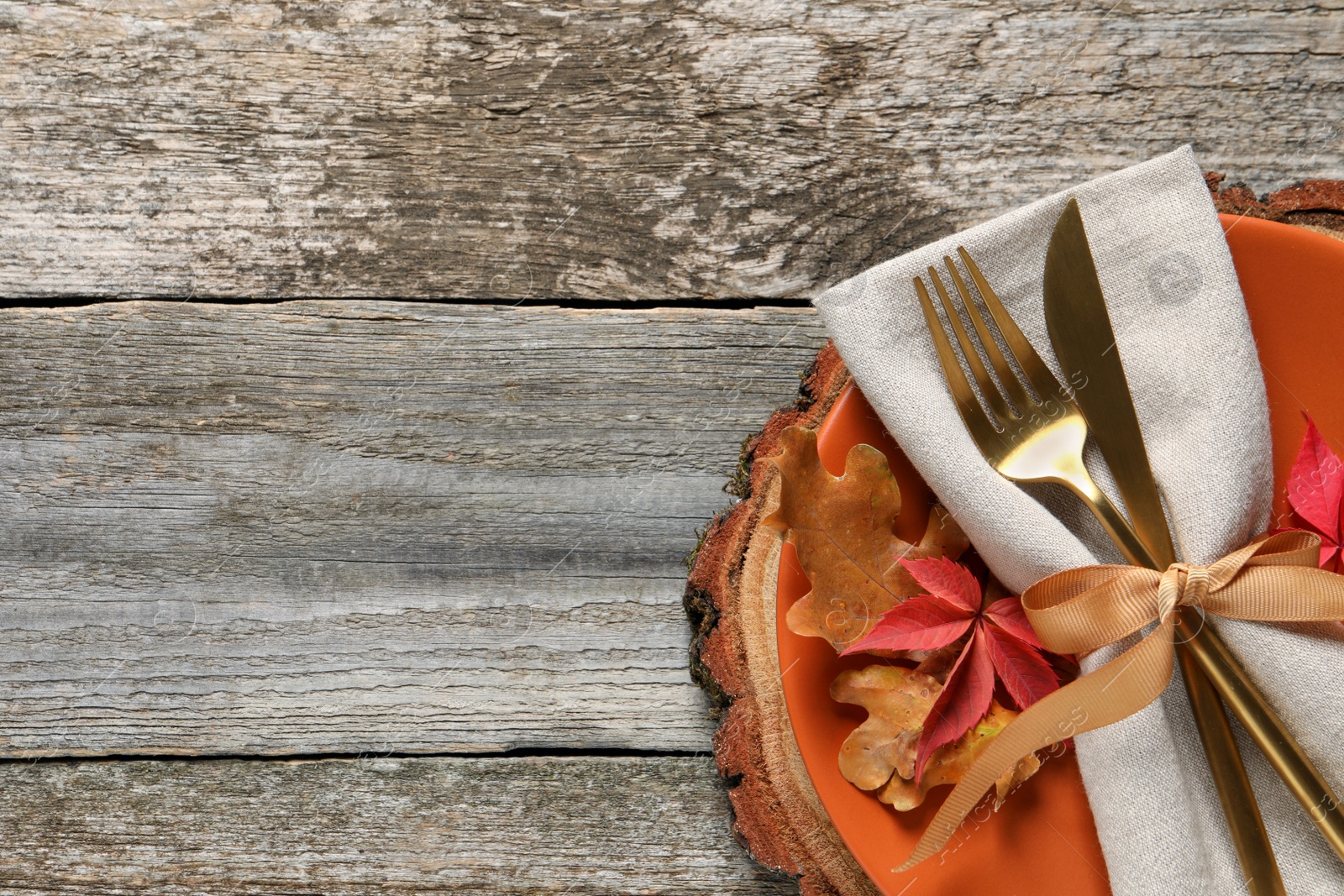 Photo of Festive table setting with autumn leaves on wooden background, top view. Space for text