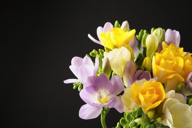 Photo of Bouquet of freesia flowers on black background. Space for text
