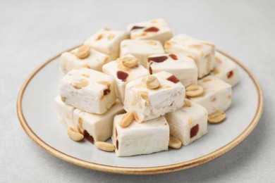 Photo of Pieces of delicious nutty nougat on light table