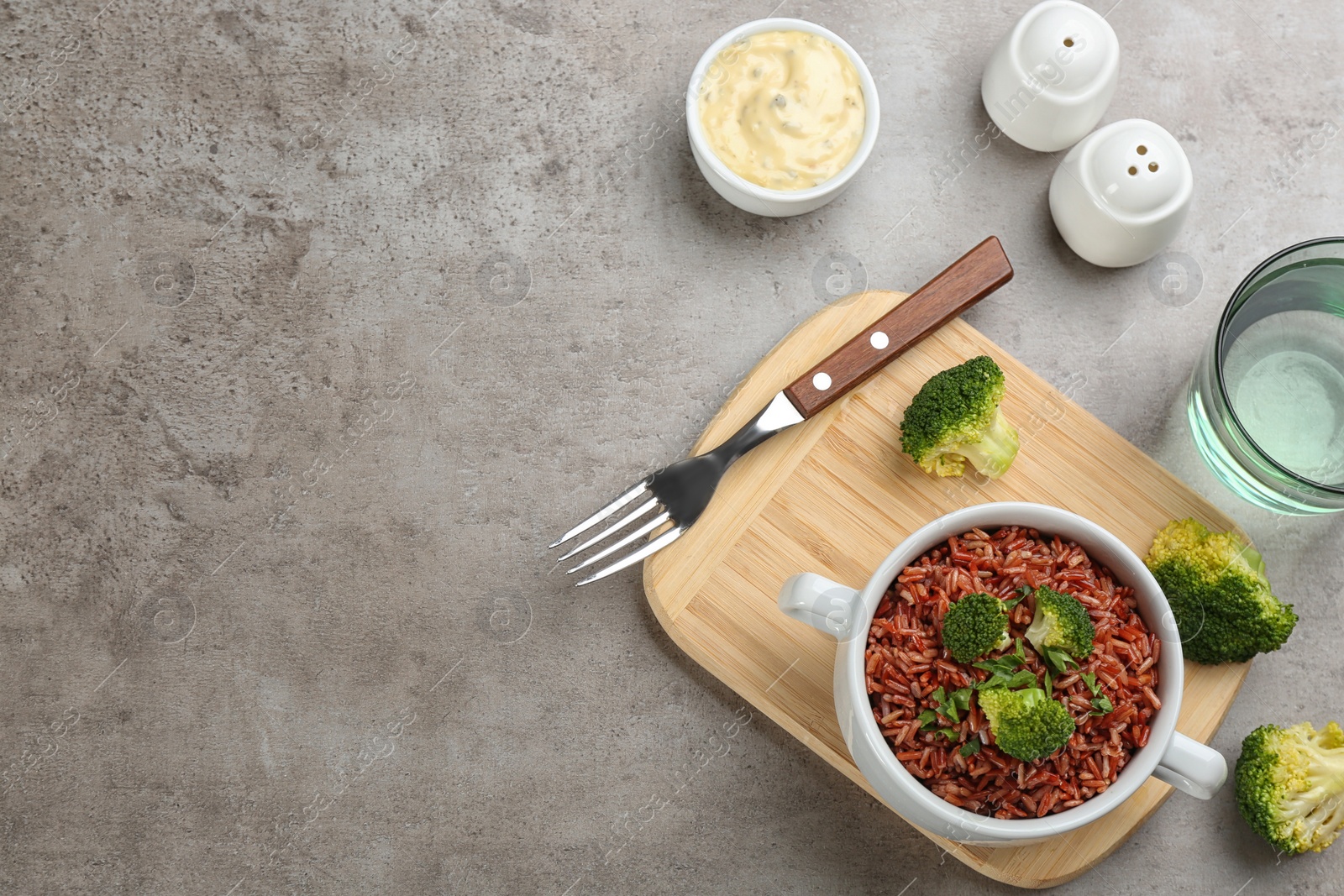 Photo of Tasty brown rice served on light grey table, flat lay. Space for text