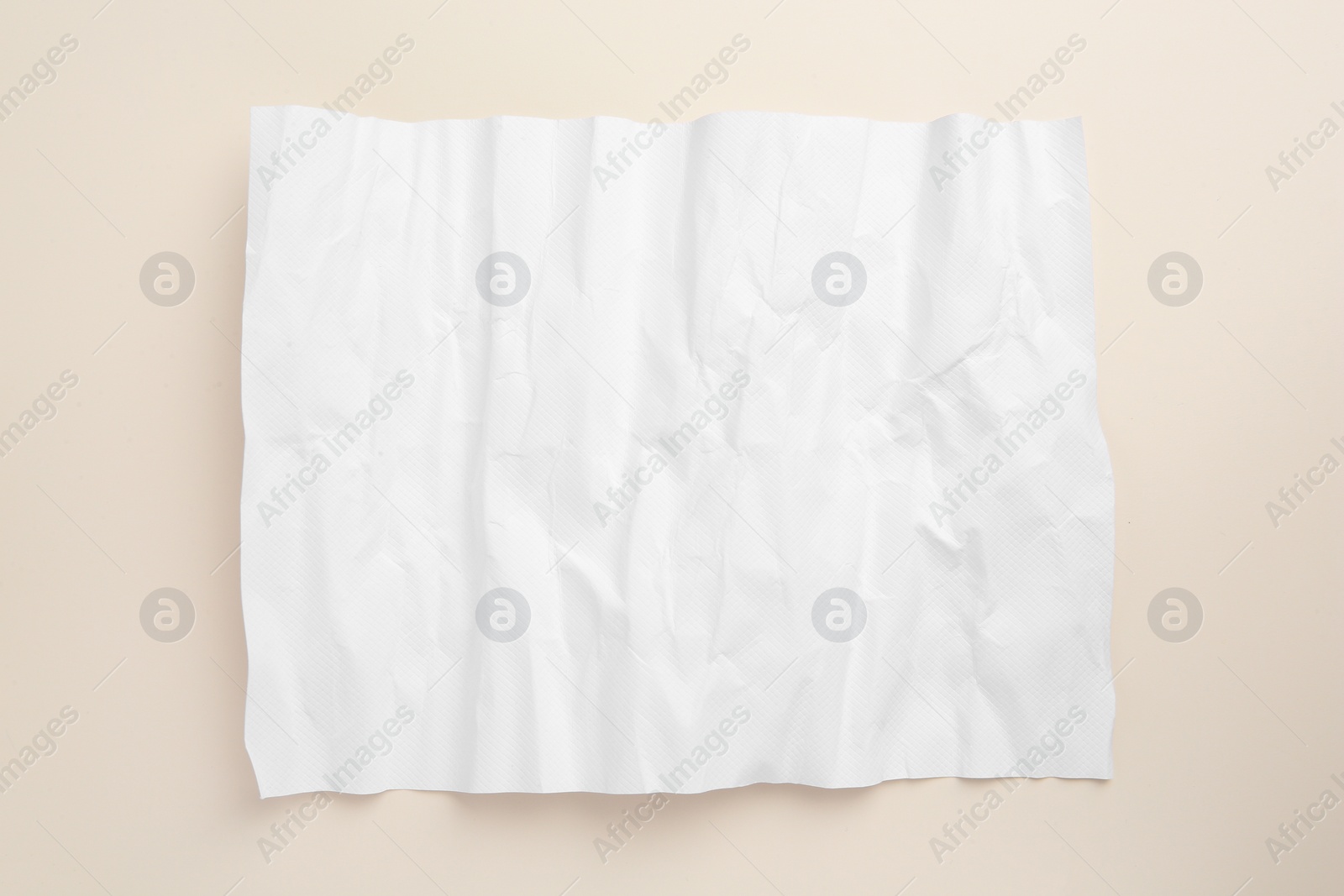 Photo of Sheet of crumpled parchment paper on beige background, top view