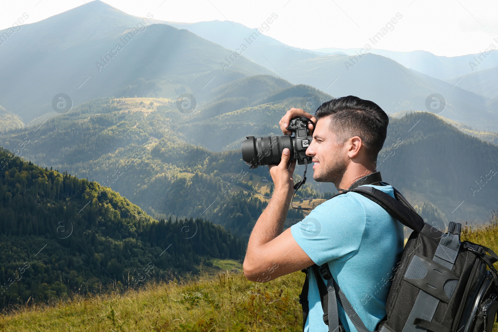 Image of Photographer taking picture of beautiful mountains with professional camera